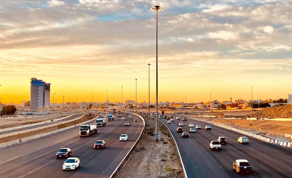 A busy highway in Saudi Arabia, packed with cars and trucks, symbolizing the country's economic activity and rapid development.